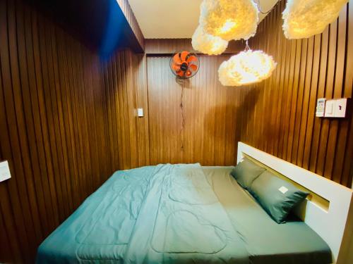 a bedroom with a bed with a wooden wall at SKY Homestay in Ấp Ðại Tài (2)