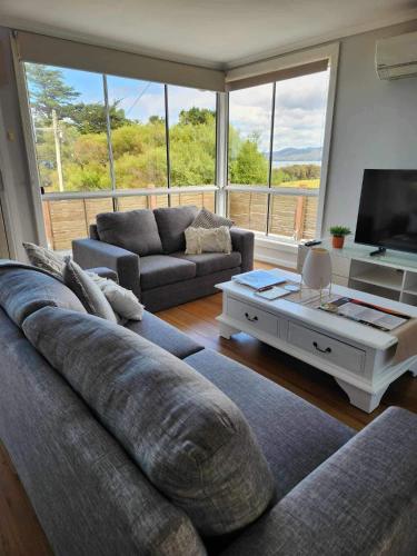 a living room with a couch and a tv at Island Escapes in Alonnah