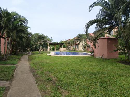 a yard with a swimming pool and palm trees at Casa el Palmar, the best house in Ixtapa in Ixtapa