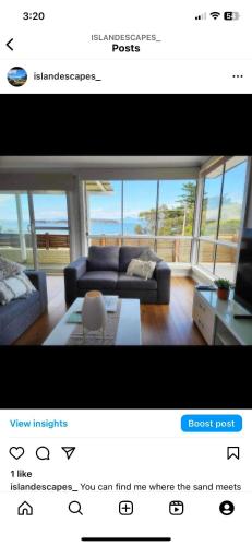 a living room with a couch and a table at Island Escapes in Alonnah