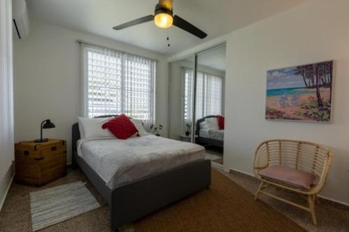 1 dormitorio con 1 cama, ventilador y silla en El Flamingo Beach Club, en Manatí