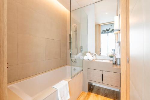 a bathroom with a tub and a sink at Address Beach Residences in Dubai