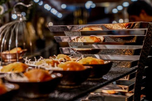 a buffet line with plates of food in bowls at The Marin Phuket Kamala Beach in Kamala Beach
