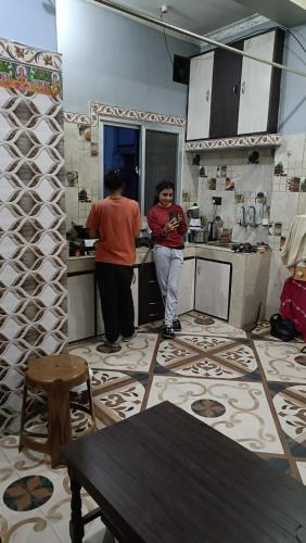 um par de pessoas em pé em uma cozinha em Mithila Culture Janakpurdham Homestay em Janakpur