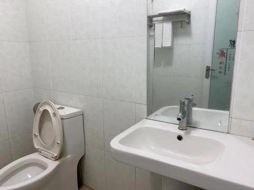 Baño blanco con aseo y lavamanos en Khách sạn Hữu Nghị 674 en Plei Khưn