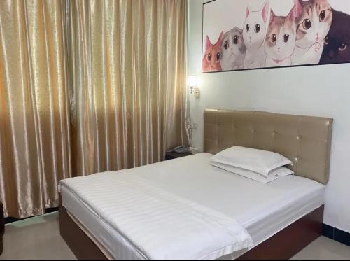 1 cama en un dormitorio con una foto de gatos en Khách sạn Hữu Nghị 674 en Plei Khưn