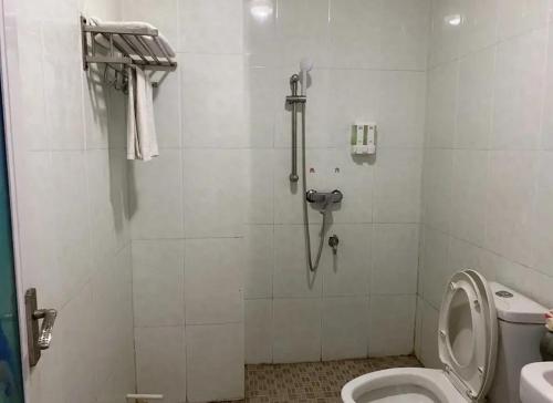 y baño con ducha, aseo y teléfono. en Khách sạn Hữu Nghị 674 en Plei Khưn