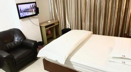 1 dormitorio con 1 cama, 1 silla y TV en Khách sạn Hữu Nghị 674 en Plei Khưn