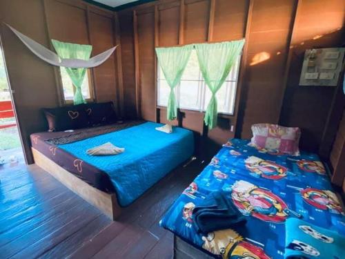 een slaapkamer met 2 bedden en een raam bij Lungcha Homestay in Sam Roi Yot