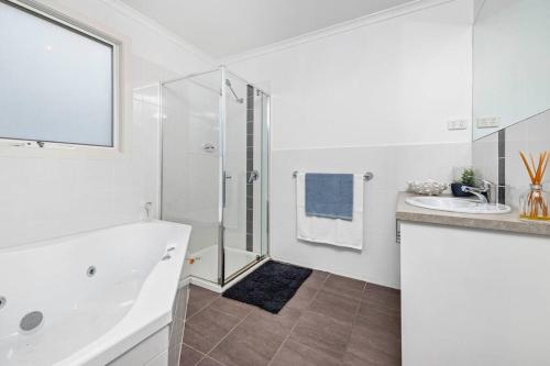 een witte badkamer met een douche en een wastafel bij Rye Getaway in Rye