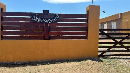 drewniana brama z napisem obok płotu w obiekcie CÁBAÑAs , S,E,2 w mieście Villa Los Aromos