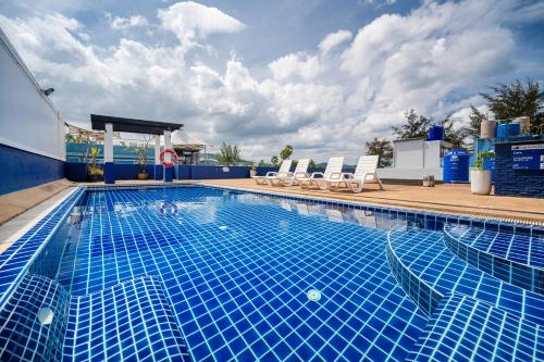 a large swimming pool with chairs at Kokotel Phuket Patong - SHA Extra Plus in Patong Beach