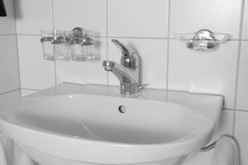 
a white sink in a bathroom next to a mirror at Richemont Hotel in Luzern
