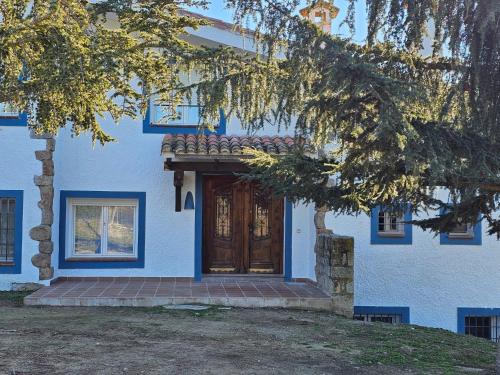 a blue house with a brown wooden door at Finca Altair in Madrid