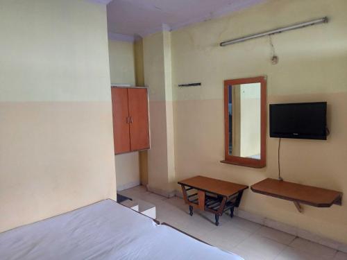 a bedroom with a bed and a desk and a mirror at OYO Hotel New Sri Sai Amaravati Lodge in Hyderabad