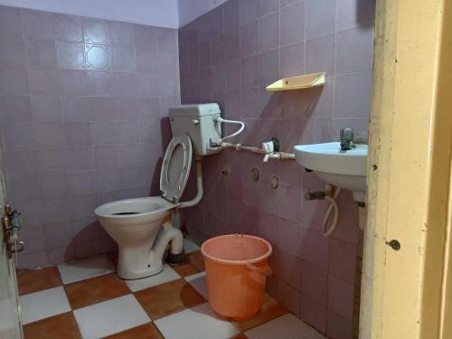 a bathroom with a toilet and a sink at OYO Hotel New Sri Sai Amaravati Lodge in Hyderabad