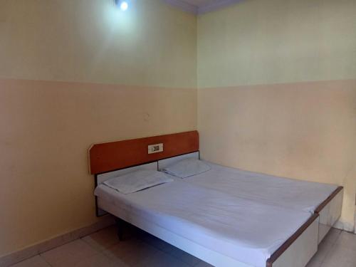 a small bedroom with a bed with white sheets at OYO Hotel New Sri Sai Amaravati Lodge in Hyderabad