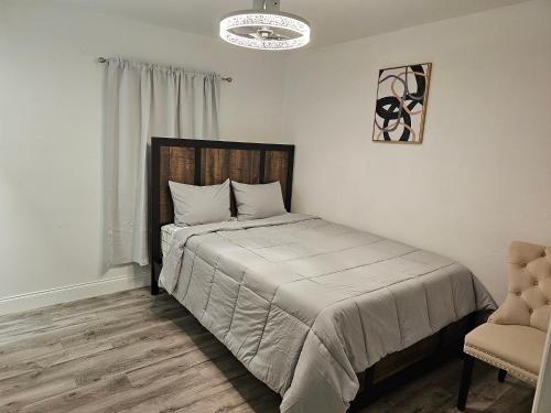 1 dormitorio con 1 cama y 1 silla en Sunny Goldie en Lauderdale Lakes