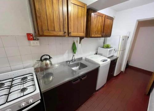 a small kitchen with a sink and a microwave at EL AMANECER - APART HUASI III in San Fernando del Valle de Catamarca