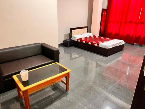 Sala de estar con 2 camas y mesa de centro en OYO Decent Inn en Imphal