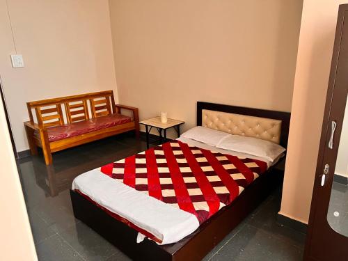 a bedroom with a bed with a red and white blanket at OYO Decent Inn in Imphal