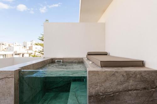 a room with a bed on top of a building at Ethereal White Resort Hotel & Spa - Adults Only in Heraklio Town