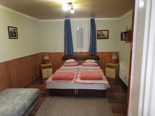 um quarto com 2 camas e cortinas azuis em Sasvár Vendégház em Parádsasvár