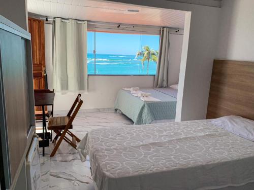 a bedroom with a bed and a view of the ocean at Pousada Ilha do Sol in Morro de São Paulo