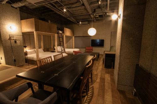 Kita-rokujōにあるGreen Room Hotelのテーブル、椅子、ベッドが備わる客室です。