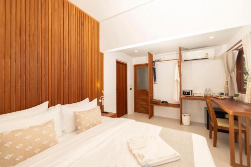 a bedroom with a bed and a desk and a table at The AVA Resort Koh Tao in Koh Tao