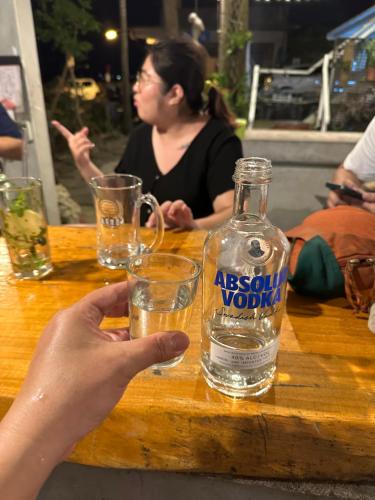 a person holding a glass of water on a wooden table at 快樂鼠樓中樓4-6人房 in Taitung City