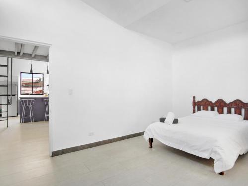 1 dormitorio con cama y pared blanca en Apartamento Bellavista en San Jose en San José