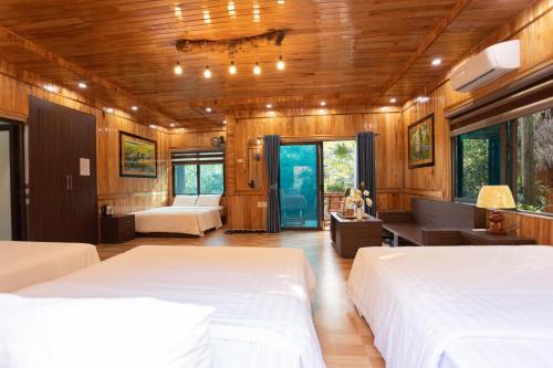 a bedroom with two beds and a living room at Hang Lan Bungalow in Ninh Binh