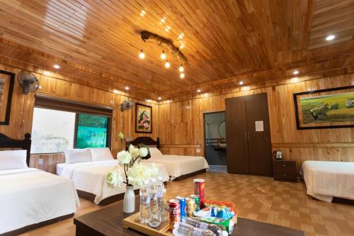 a room with two beds and a table with flowers at Hang Lan Bungalow in Ninh Binh