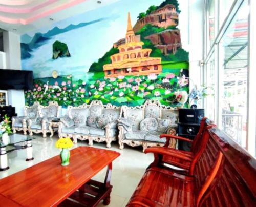 un salon avec des canapés et une grande fresque murale. dans l'établissement โรงเเรมคิงส์พาเลซ King's Palace HOTEL, à Seka
