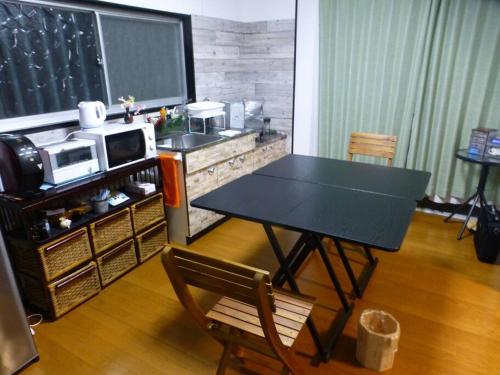 a dining room with a table and a microwave at こや・かやき in Yufuin
