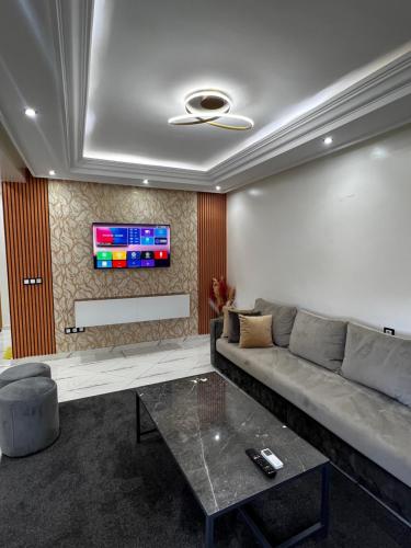 a living room with a couch and a tv at Duplex familial 3 chambres au cœur de la Corniche de Tanger in Tangier