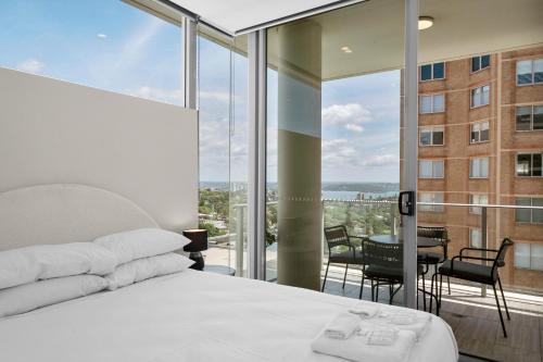 1 dormitorio con 1 cama y balcón con vistas. en Spectacular City & Harbour Views: Bondi Junction, en Sídney