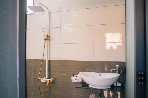 a bathroom with a white sink and a shower at Homestay Bến Tre in Ben Tre