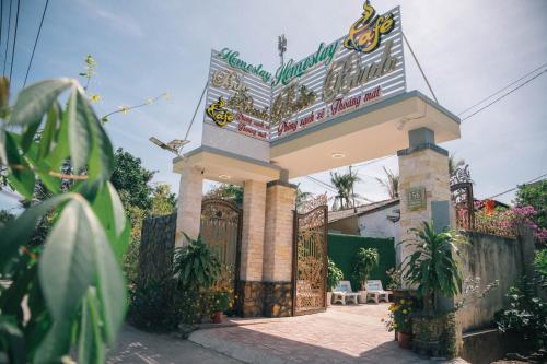 a gate to a restaurant with a sign on it at Homestay Bến Tre in Ben Tre