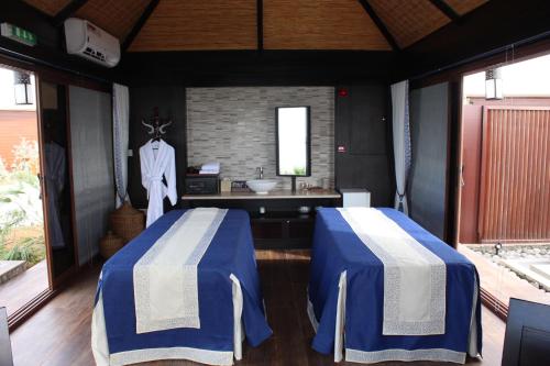 a bathroom with two beds and a sink in it at The Ritz-Carlton Ras Al Khaimah, Al Hamra Beach in Ras al Khaimah