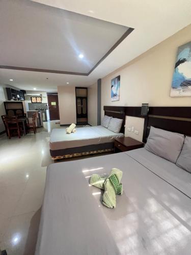 a bedroom with two beds and a living room at Dante's Hideaway Guest House in Boracay
