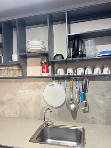 a kitchen counter with a sink and utensils at Dante's Hideaway Guest House in Boracay