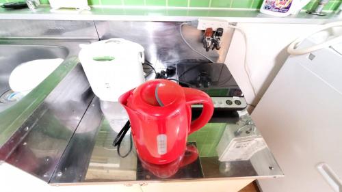 a red pair of scissors sitting on top of a machine at 札幌市中心部大通公園まで徒歩八分観光移動に便利なロケーションe507#28b in Sapporo