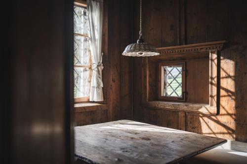 een kamer met een tafel en twee ramen bij Ansitz Heufler in Rasun di Sopra