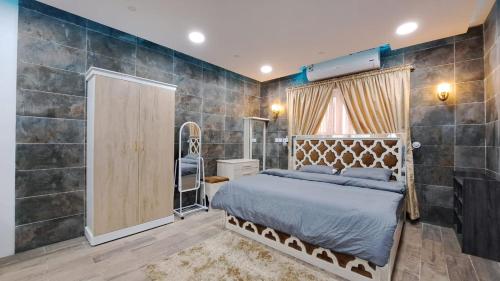 ein Schlafzimmer mit einem Bett und einer großen gefliesten Wand in der Unterkunft ستوديو دور ارضي كامل بمطبخ وحوش وكراج خاص. in Al Hofuf