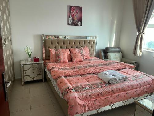 a bedroom with a large bed with pink blankets and pillows at Discover Khorfkan in Khor Fakkan