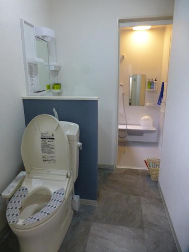 a bathroom with a toilet with the lid up at こや・かやき in Yufu