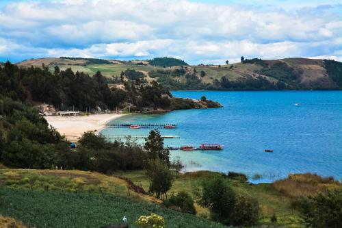a view of a beach with boats in the water at Cabañas los Sauces in Tota