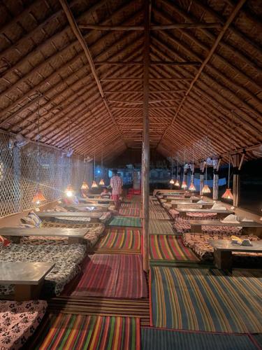 Hampi Social Resort في هامبي: غرفة كبيرة مع صفوف من الأسرة على الأرض